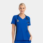 A blue women's mock wrap top featuring contrast black panels and a pocket, worn with a stethoscope.
