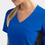 A blue mock wrap top features contrast black panels on the sides, designed for women.