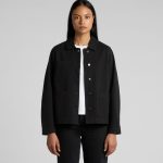 A black canvas chore jacket with a collared neckline and front pockets, modelled by a woman.