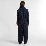 A person wearing navy canvas coveralls viewed from the back, featuring a relaxed fit and elasticised waist.