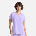 A lilac women's dolman top featuring a v-neck, short sleeves, and a pocket, with a subtle logo.