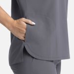 A grey women's top features a rounded hem and a side pocket, showcasing a sleek and comfortable design.