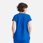 A blue women's Dolman top featuring three pockets, shown from the back on a model with curly hair.