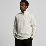 A cream Stencil Half Zip Crew jumper featuring a high collar and a zip closure, worn by a model.