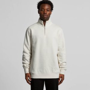 A man is wearing a cream-coloured half zip crew jumper with a relaxed fit, featuring a stand-up collar.