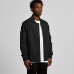 A black bomber jacket displayed on a model, featuring a zip closure and long sleeves. The jacket has a logo on it.