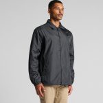 A black coach jacket featuring a point collar and elasticised cuffs, with a logo present.