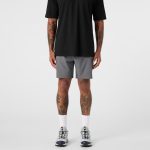 A pair of grey sports shorts paired with a black top, worn by a person with visible tattoos.