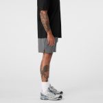 Active shorts in grey, featuring a side view with a black t-shirt and athletic shoes, complete with a logo.