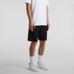 Black sports shorts with a drawstring, featuring a logo, worn with a white T-shirt and white sneakers.