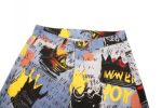 A pair of shorts with a colourful graphic print featuring various designs in blue, yellow, black, and red.