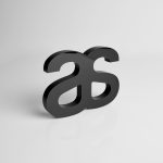 A sleek black plaque featuring a stylised logo design. The surface has a glossy finish, reflecting light subtly.