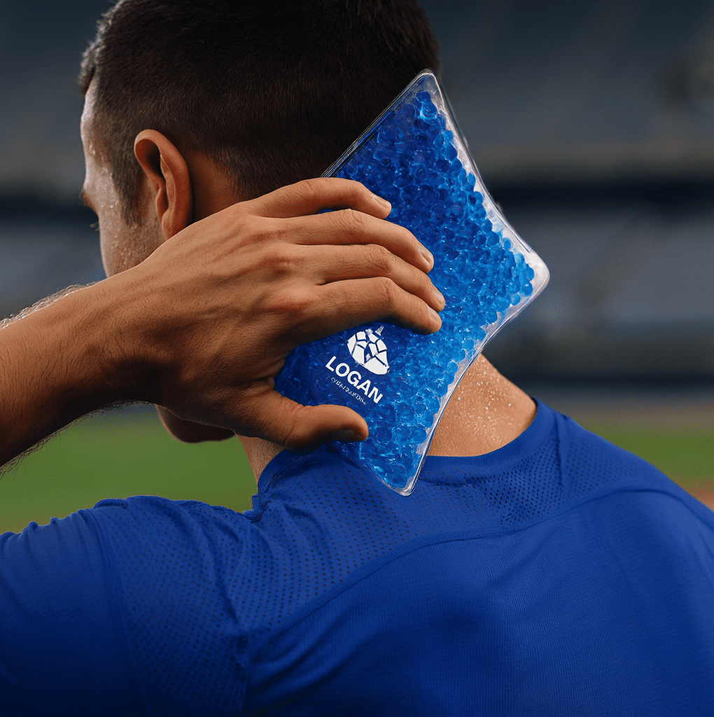 A blue Caviar Bead Cooling Pack held against the neck of a person wearing a blue athletic shirt. The pack has a logo. Caviar Bead Cooling Pack - Image 1