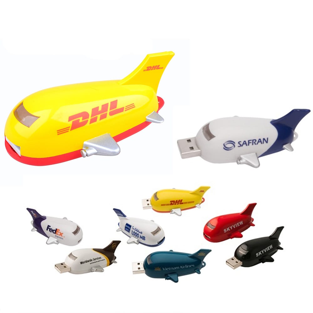 A set of colourful aircraft-shaped flash drives in yellow, white, and black, featuring various brand logos. Aircraft Flash Drive - Image 1