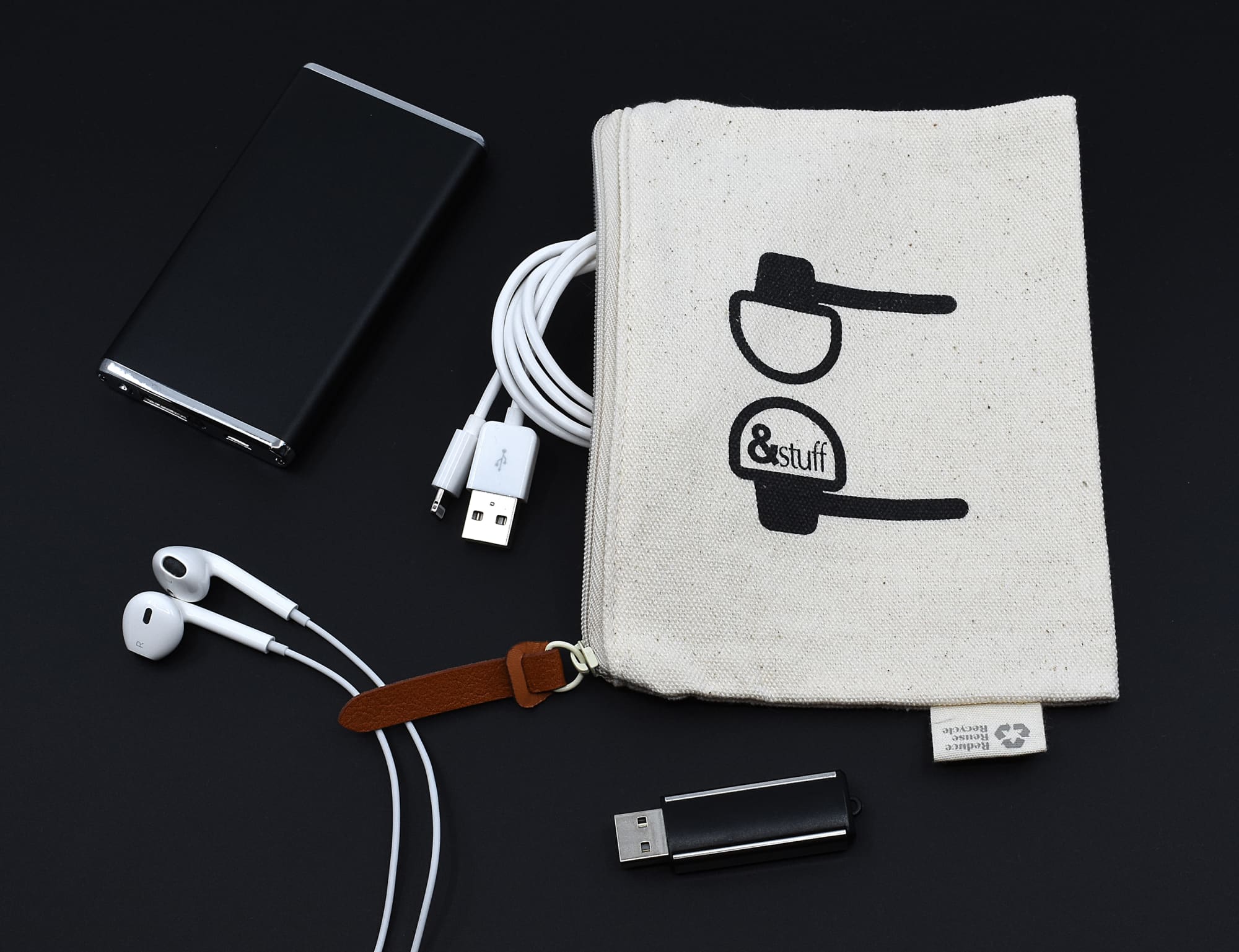 A neutral calico earphone pouch with a logo, surrounded by earphones, USB cables, and a portable charger. Calico Earphone Pouch 12.5cm x 17cm - Image 1