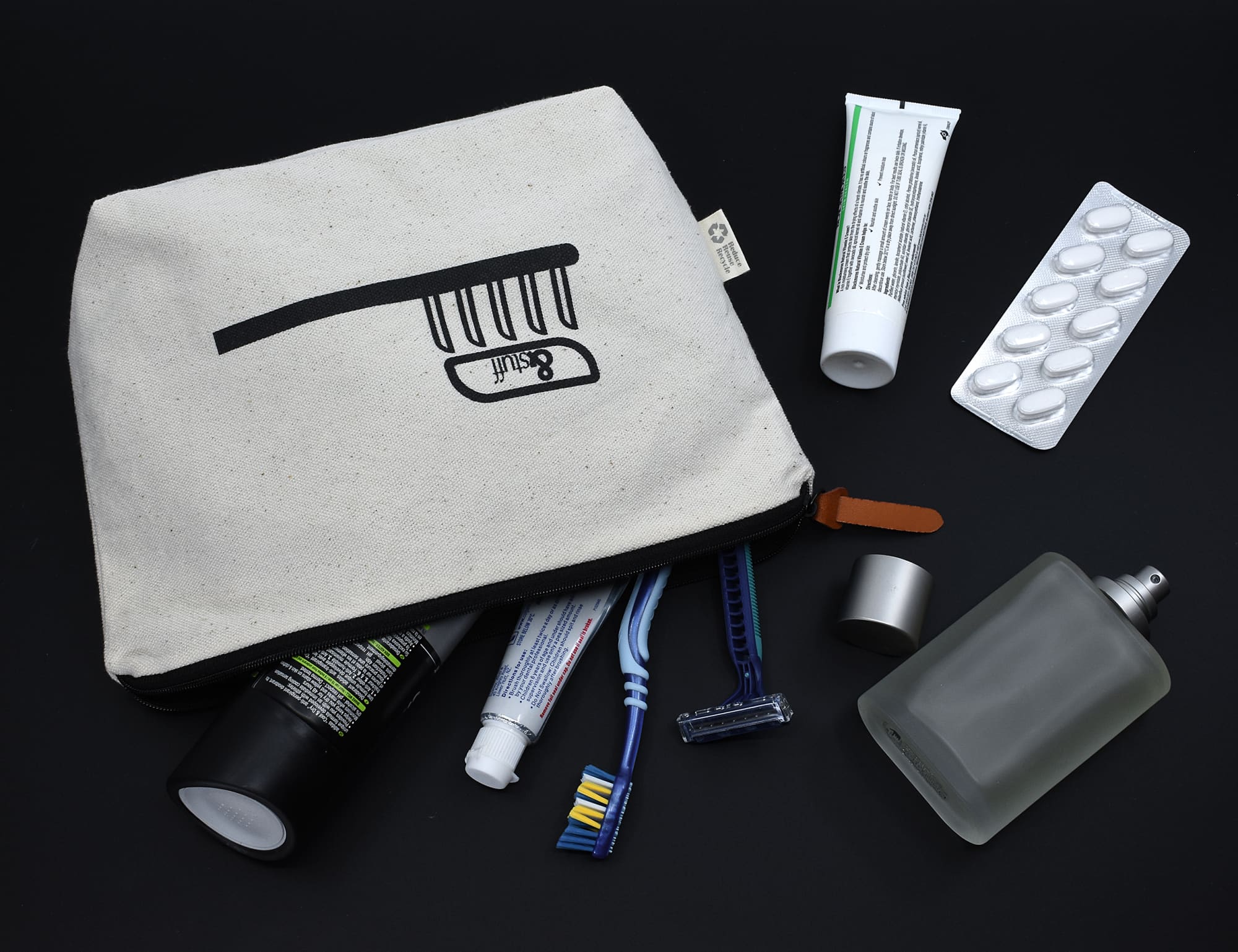 A cream-coloured toiletry bag with a zipper, containing toiletries such as tubes, razors, and a perfume bottle. Calico Toiletry/Makeup Bag 17x27x8.5cm - Image 1