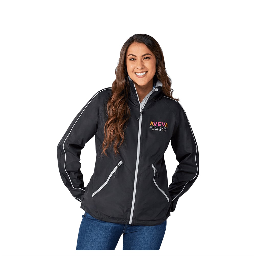 A woman in a black eco-friendly packable rain jacket with a logo, featuring zippered pockets and reflective details. Rincon Eco Packable Jacket - Womens - Image 1