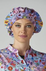 A bouffant cap in pink, featuring a colourful print of flowers and butterflies, worn by a woman.