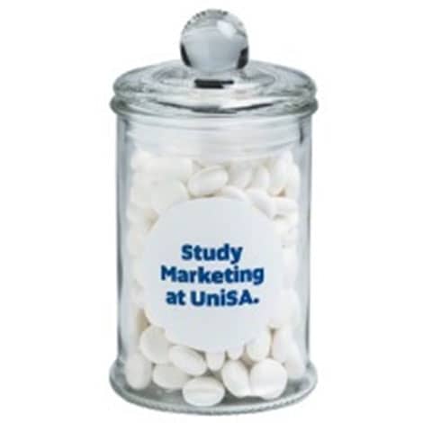 A clear apothecary jar containing white chewy mints, topped with a round lid and featuring a logo. Small Apothecary Jar with Chewy Mints 115g - Image 1