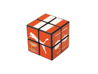 A 2x2 Rubik's Cube in orange and black, featuring a logo on one side. Rubik's Cube 2x2 38mm - Image 1