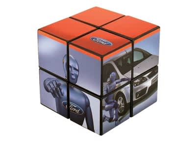A Rubik's Cube featuring a predominantly orange design with automotive graphics and branding. It has six sides with various images. Rubik's Cube 2x2 57mm - Image 1