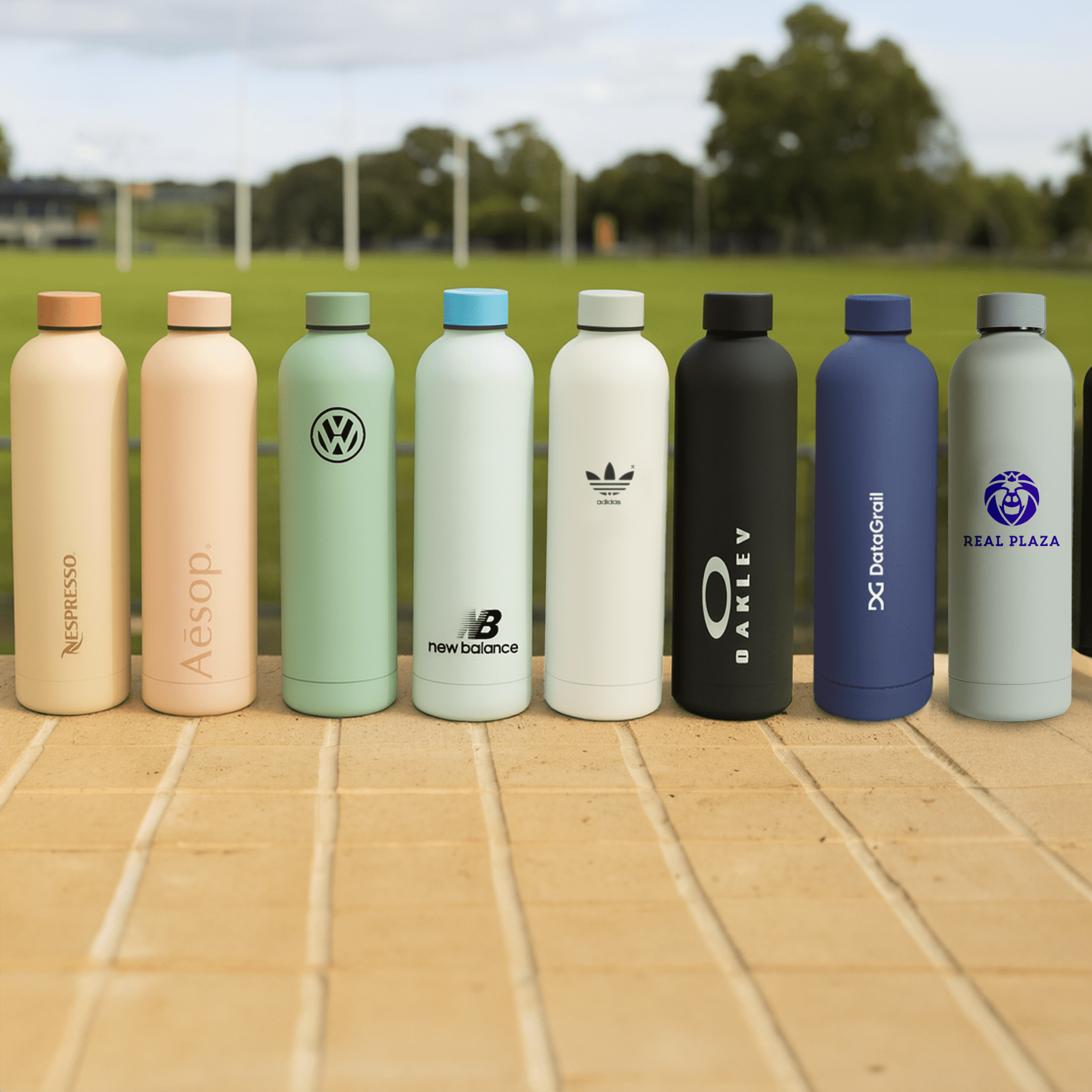 A drink bottle collection featuring various designs and colours, including pale pink, mint green, black, and blue, with branding. Allegra 750ml Bottle - Image 1