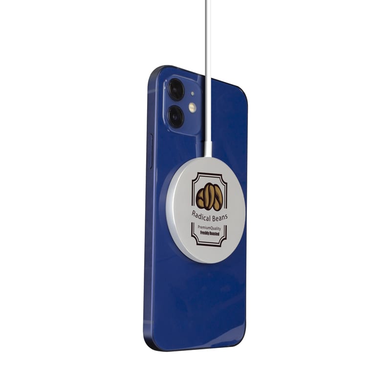 A blue smartphone with a white, circular magnetic wireless charger attached, featuring a logo. Tauris 15W Magnetic Wireless Charger - Image 1