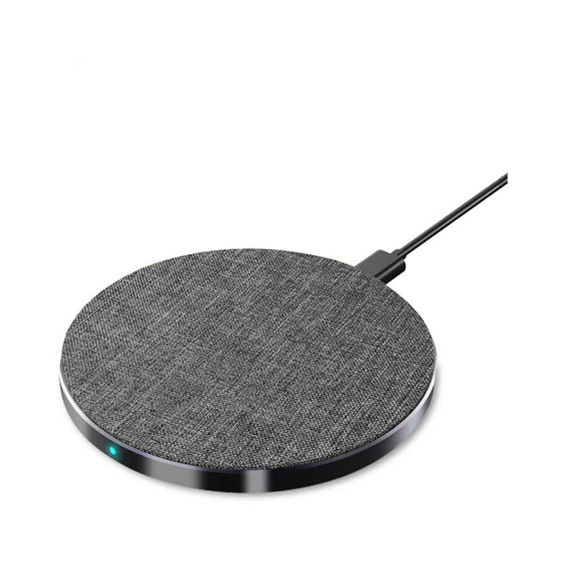A round, grey wireless charger with a textured surface and a connecting cable. It features a small indicator light. Tweed Fast Wireless Charger - Round - Image 1