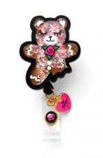 A cute, glittery gingerbread bear badge in brown and pink, featuring a heart-shaped charm and a logo.