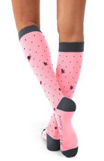 A pair of pink compression socks with polka dots and a logo, featuring a grey cuff and sole.