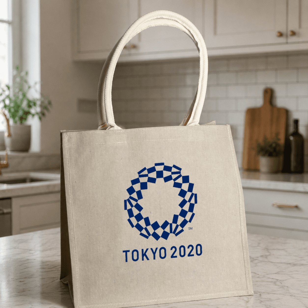 A jute tote bag in a natural colour with a logo design in blue. Features sturdy handles and a structured shape. Jabali Jute Tote Bag - Image 1