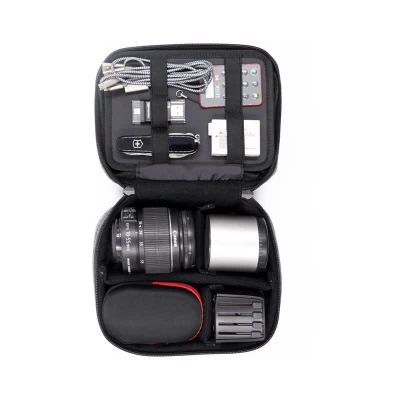 A black accessory case filled with a camera lens, battery packs, cables, a multi-tool, and a memory card. Folio Pro Accessory Pack (Stock) - Image 1