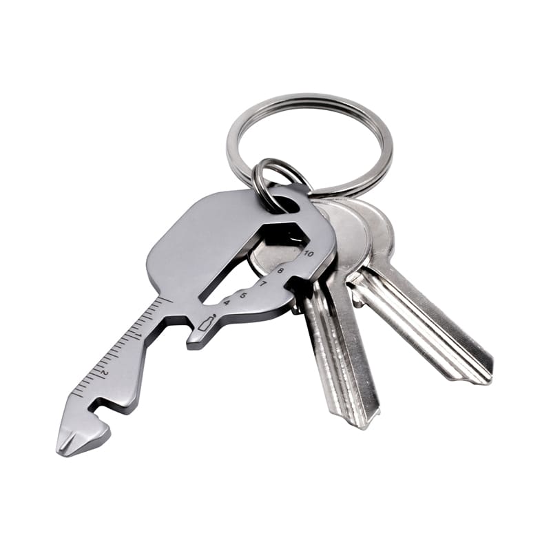 A multi-tool keyring in metallic grey with several standard keys attached. The tool features measuring lines and a unique shape. Kee Multi-tool - Image 1