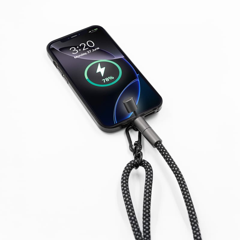 A phone strap with a braided black cable connected to a smartphone, displaying a charging icon on the screen. Lany Charge Eco Phone Strap (60 Watt Charge & Data Cable) - Image 1