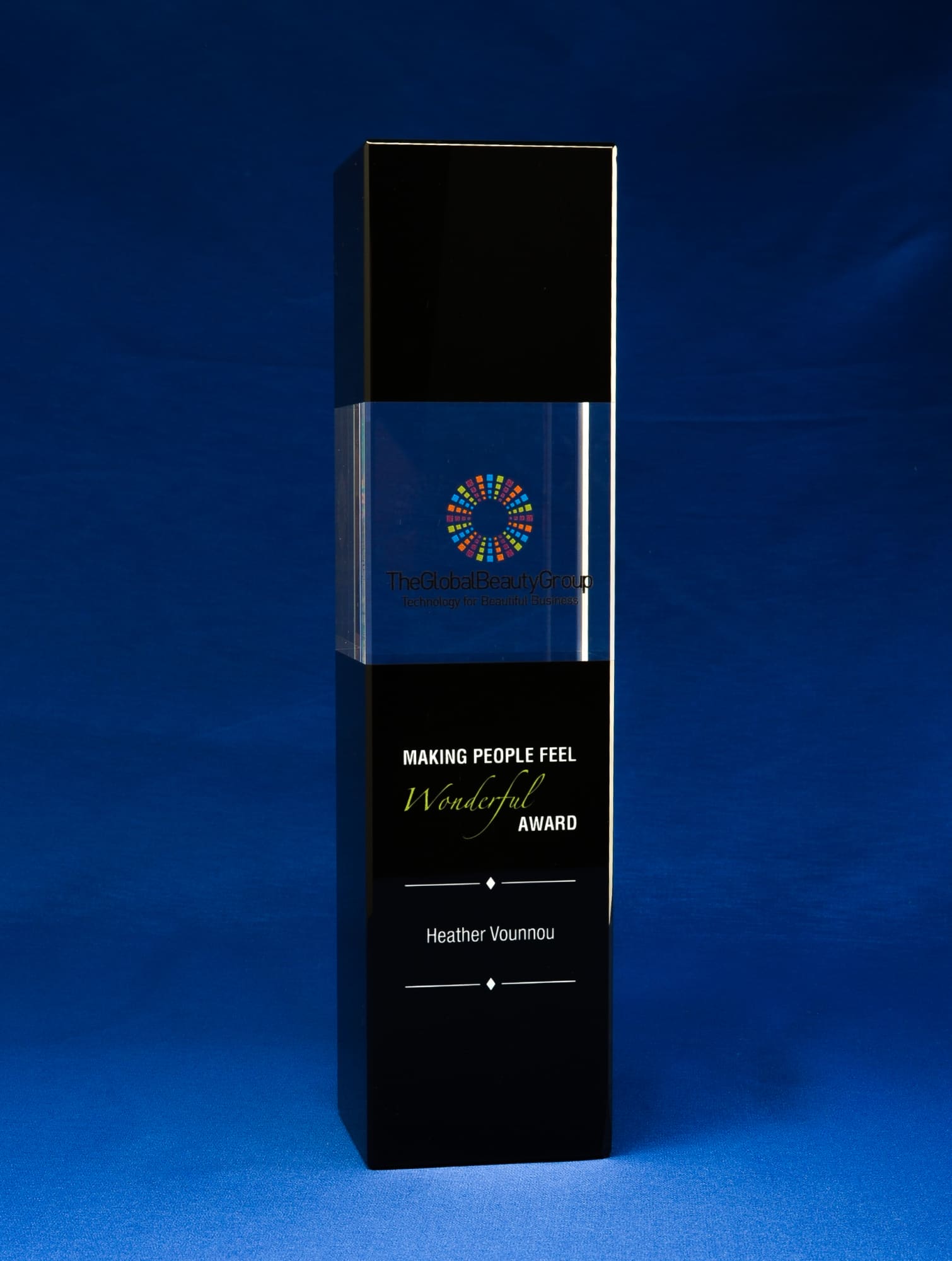 A tall, elegant crystal award featuring a clear top and a black base, with a logo on the front. Noir Clair Crystal Tower Award - Image 1