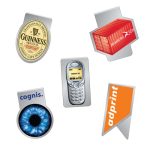 A collection of five promotional items, including a bottle cap, mobile phone, shipping container, and two logo badges.