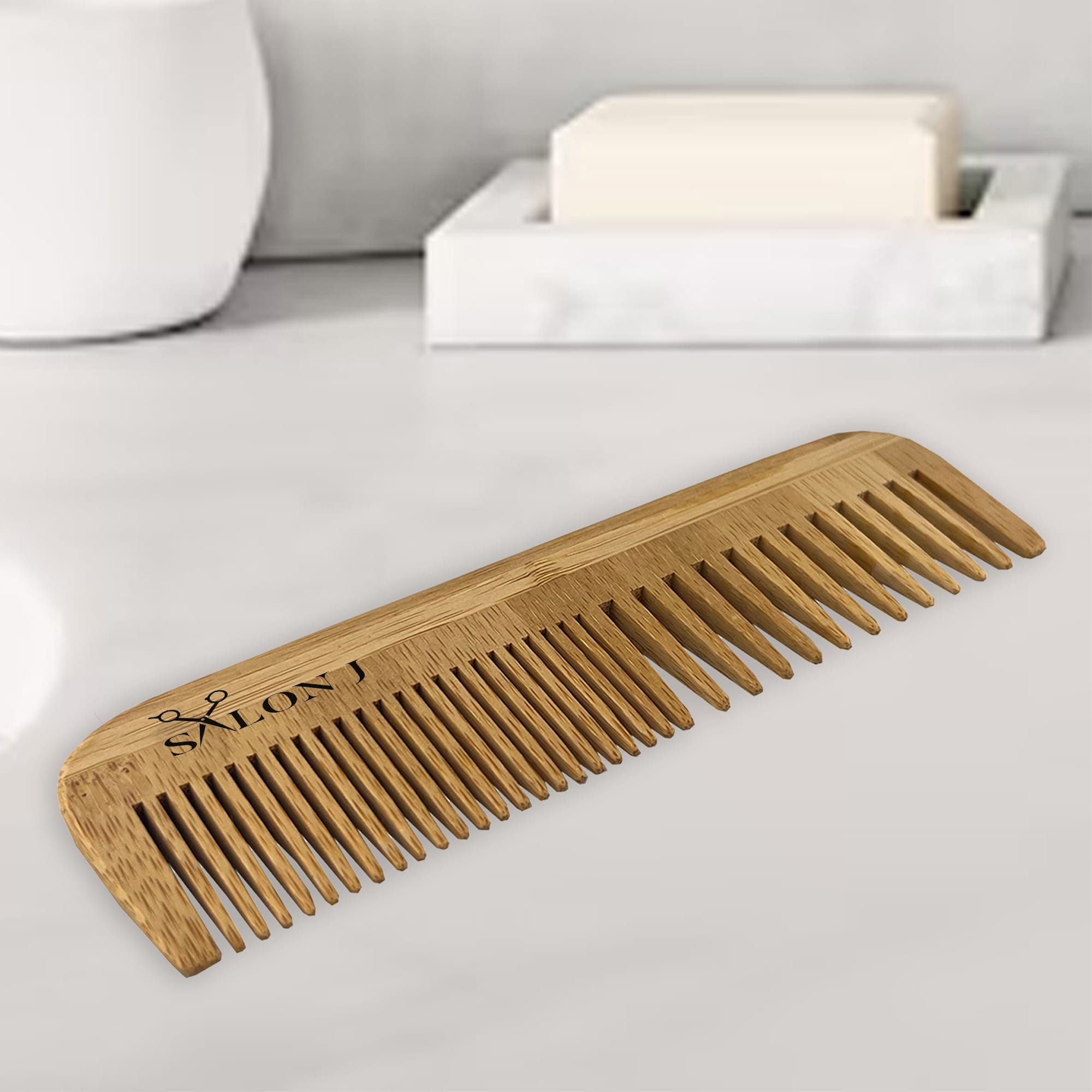 A bamboo comb in natural tones with a branded logo, placed on a marble surface next to a soap bar. Silo Bamboo Comb - Image 1