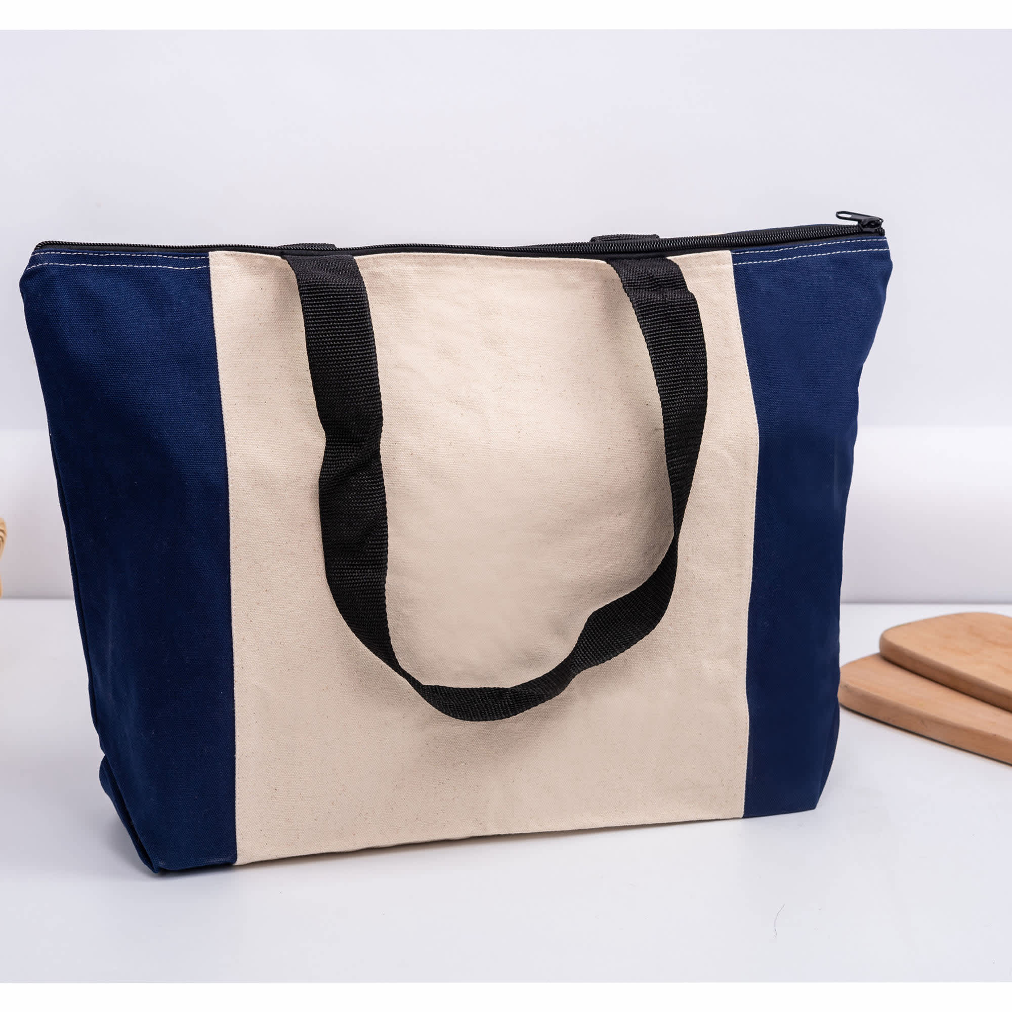 A tote bag featuring a navy blue and cream design, with black handles and a zip closure. Calico Zip Shopper - Image 1