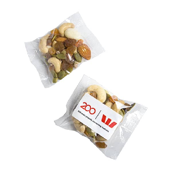 A clear sachet containing a mix of nuts and seeds, featuring cashews, almonds, and pumpkin seeds. It has a logo on the packaging. Trail Yoghurt Nut Mix 25g - Image 1