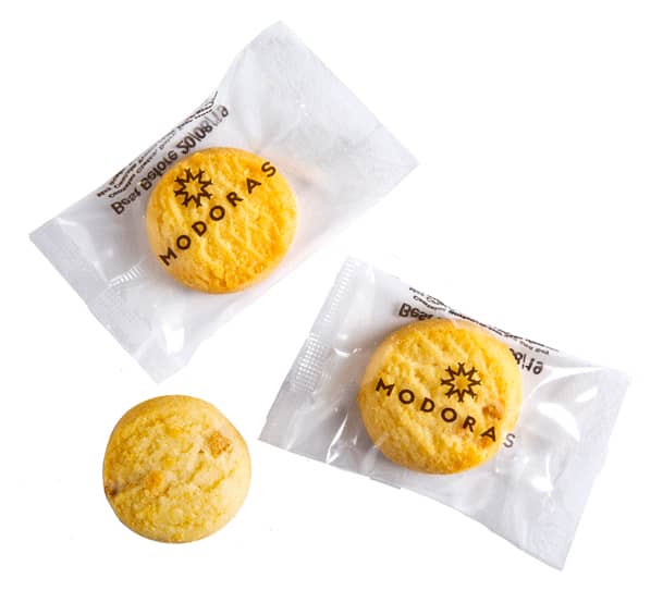 Three bite-sized biscuits in clear packaging, featuring a logo. Biscuits are golden yellow with a textured surface. Bite Size Biscuit 5g - Image 1