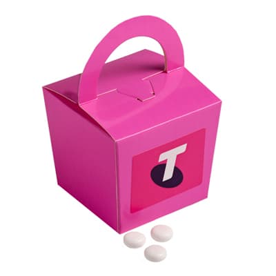 A pink noodle box with a handle containing white mints. The box features a logo on one side. A pink noodle box with a handle containing white mints. The box features a logo on one side.