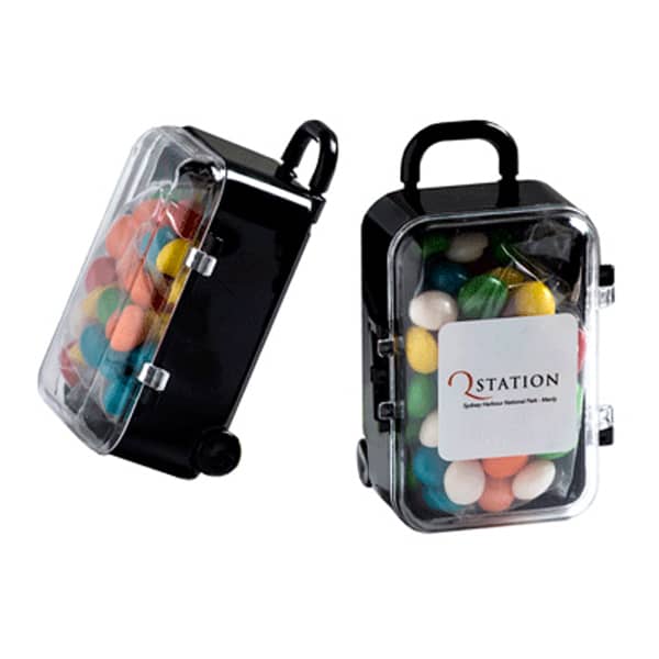 A small black carry-on case filled with colourful chewy fruit candies, featuring a clear lid and a logo. Carry-On Case with Chewy Fruits 50g - Image 1