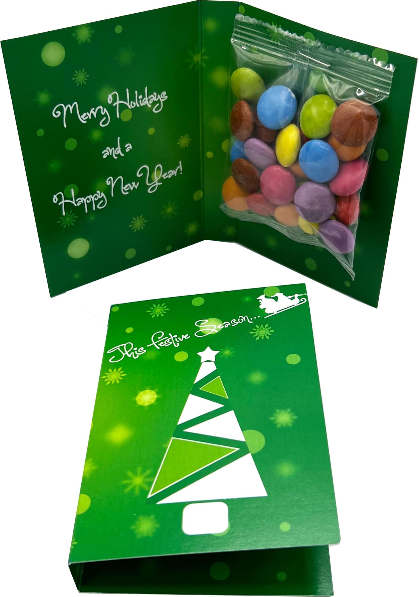 A green card featuring a Christmas tree design, containing a clear bag of colourful Smarties. A green card featuring a Christmas tree design, containing a clear bag of colourful Smarties.