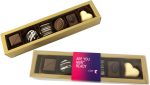 A gold box containing assorted pralines, including dark, milk, and white chocolates, with decorative patterns.