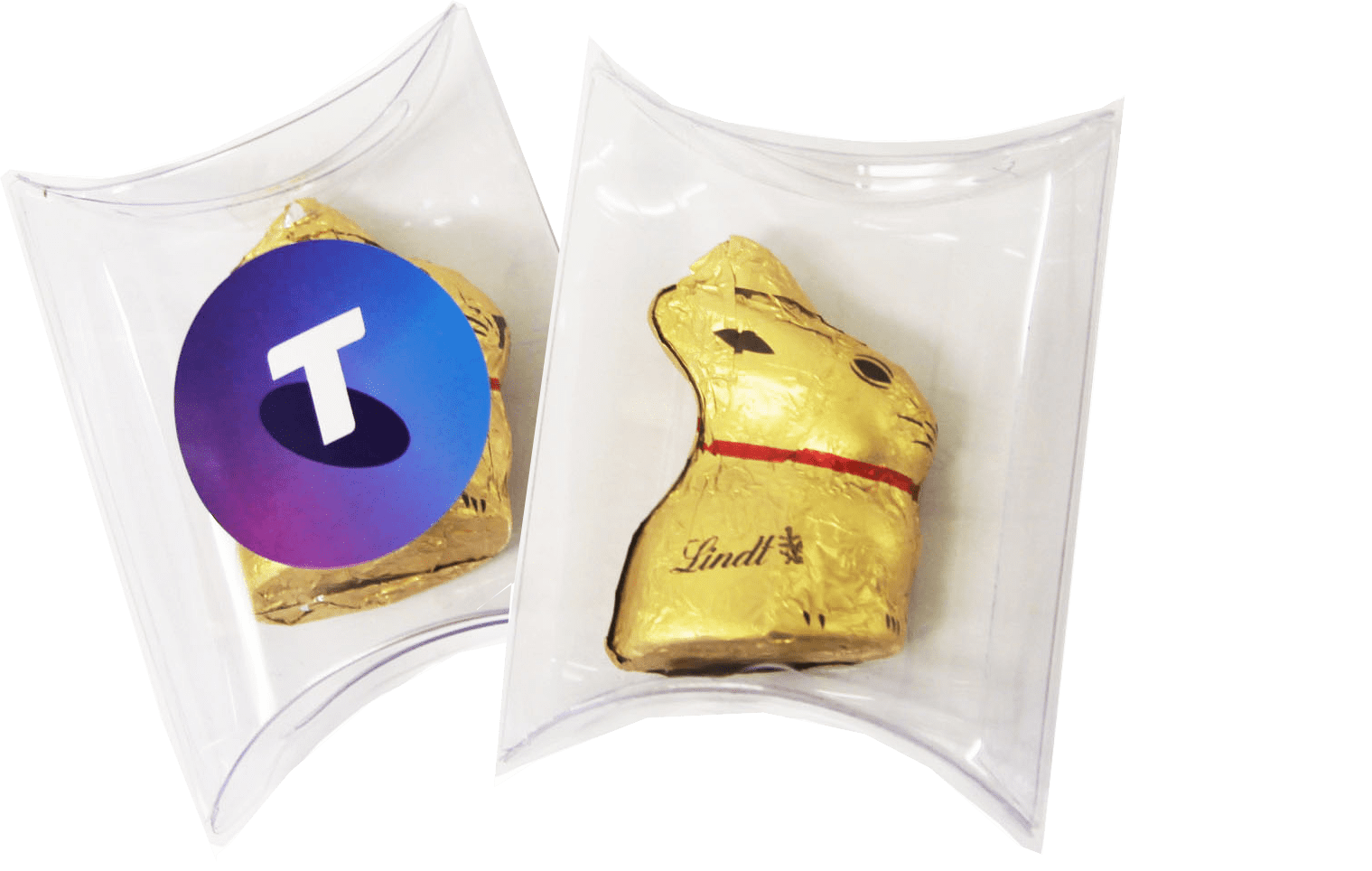 A clear pillow pack containing a gold 10g Lindt Bunny with a logo on one side and the bunny visible on the other. Pillow Pack with Gold 10g Lindt Bunny - Image 1