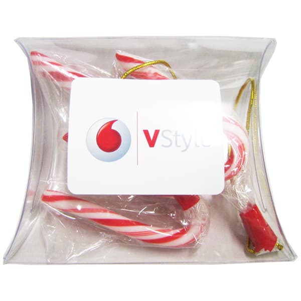 A clear pillow pack containing red and white striped candy canes, featuring a branding logo on the front. Pillow Pack filled with Candy Canes - Image 1