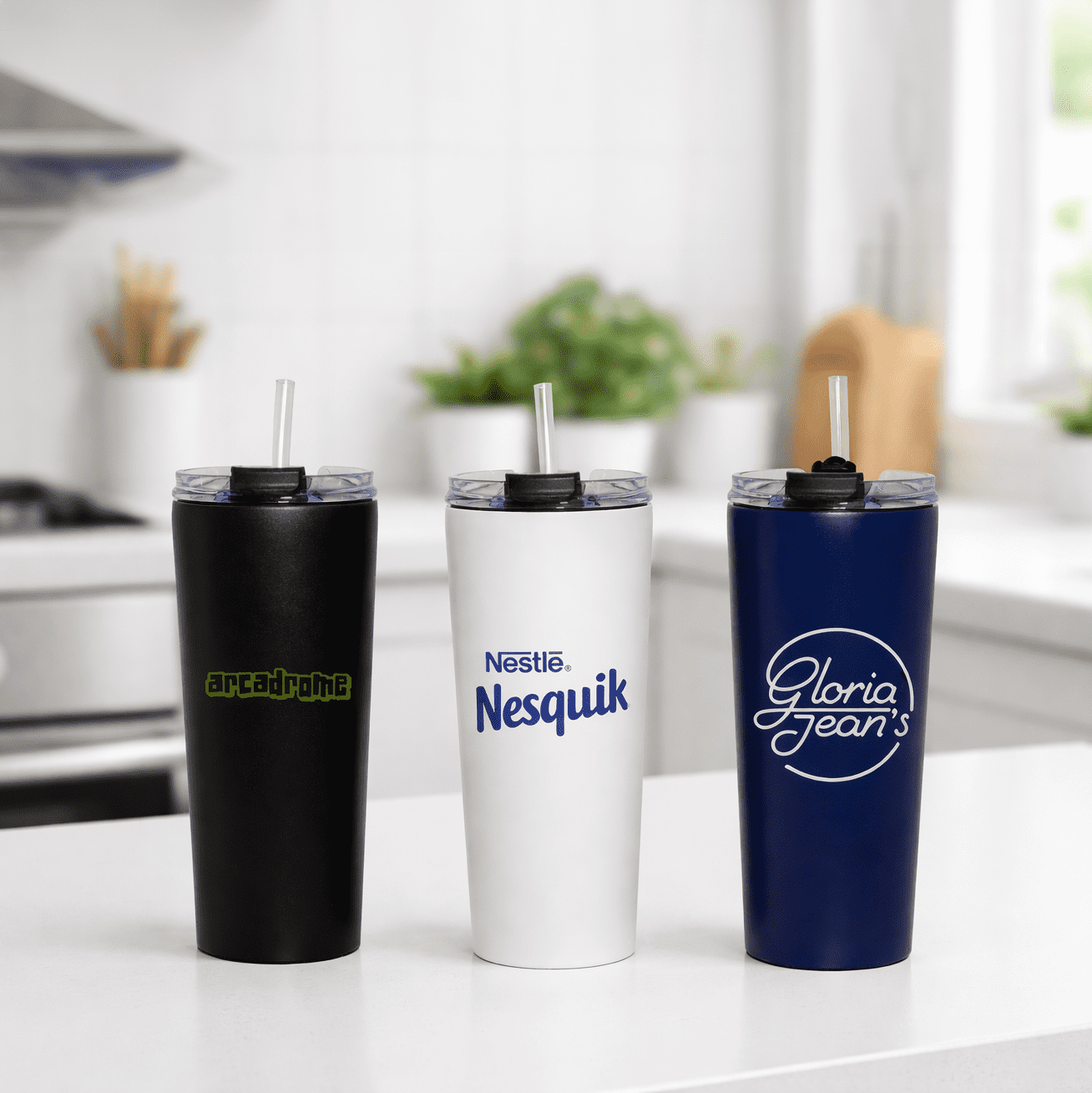 Three vacuum tumblers in black, white, and navy blue, each with a straw and a logo on the front. The Connor 600ml Vacuum Tumbler - Image 1