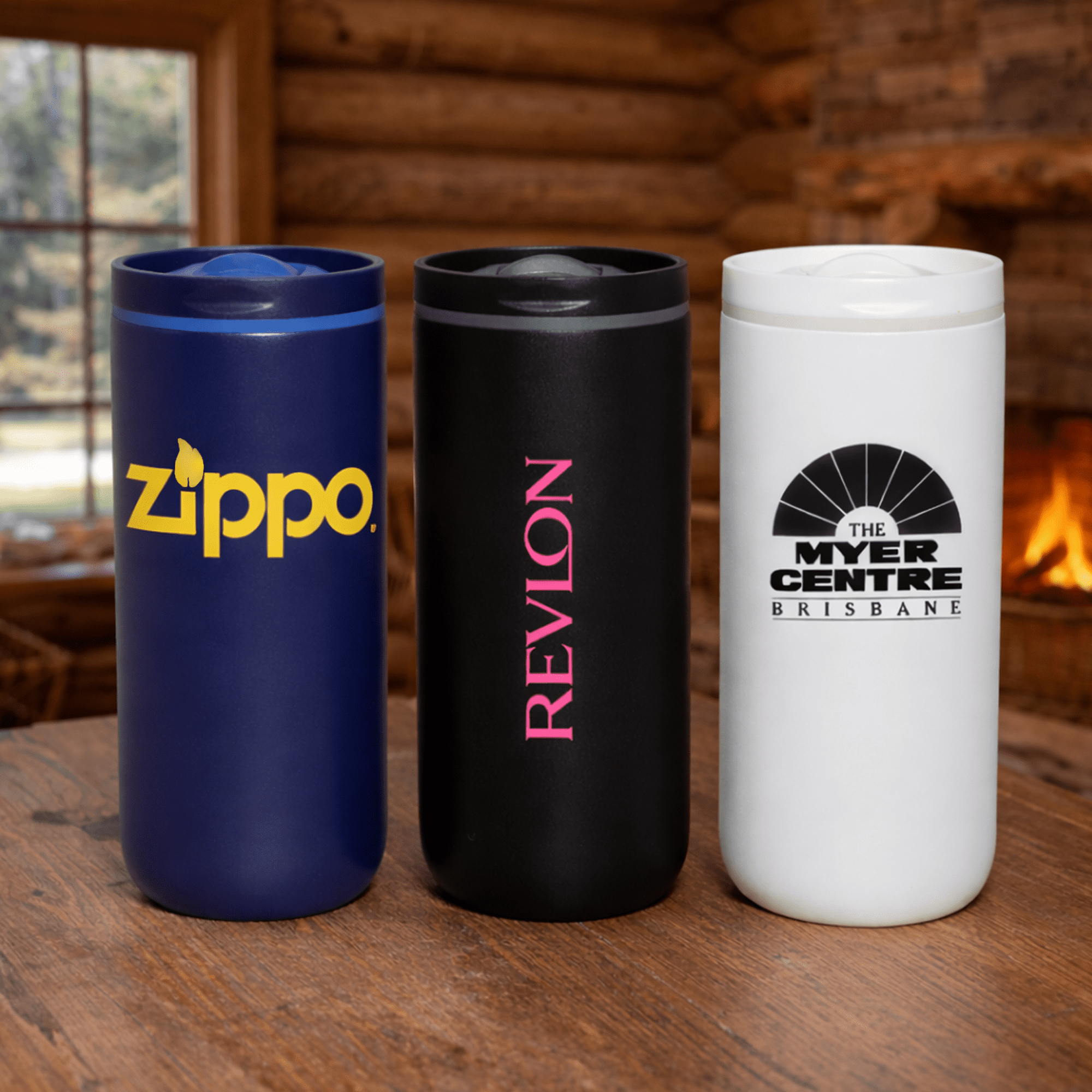 A drink bottle trio featuring a navy blue, black, and white vacuum tumbler with various logos. The Siena 450ml Vacuum Tumbler - Image 1