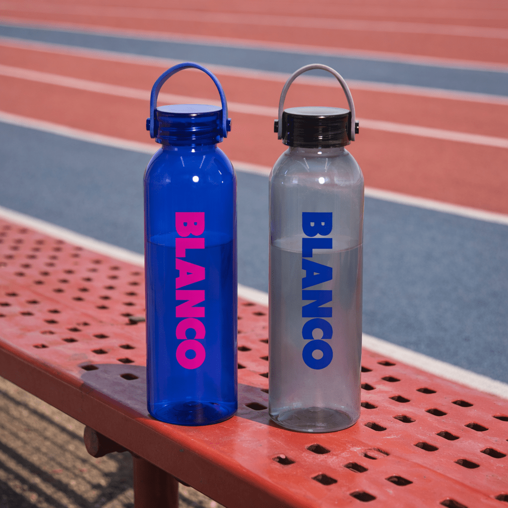 A drink bottle set featuring a blue and a clear design, both with a logo and cap, resting on a bench. Clearview RPET 630ml Drink Bottle - Image 1