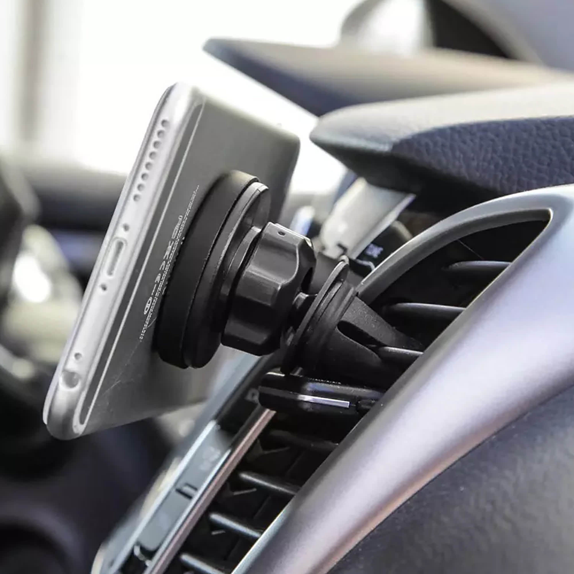 A car phone holder in black attaches to a vehicle's air vent holding a smartphone securely in place. Car Mobile Holder - Image 1